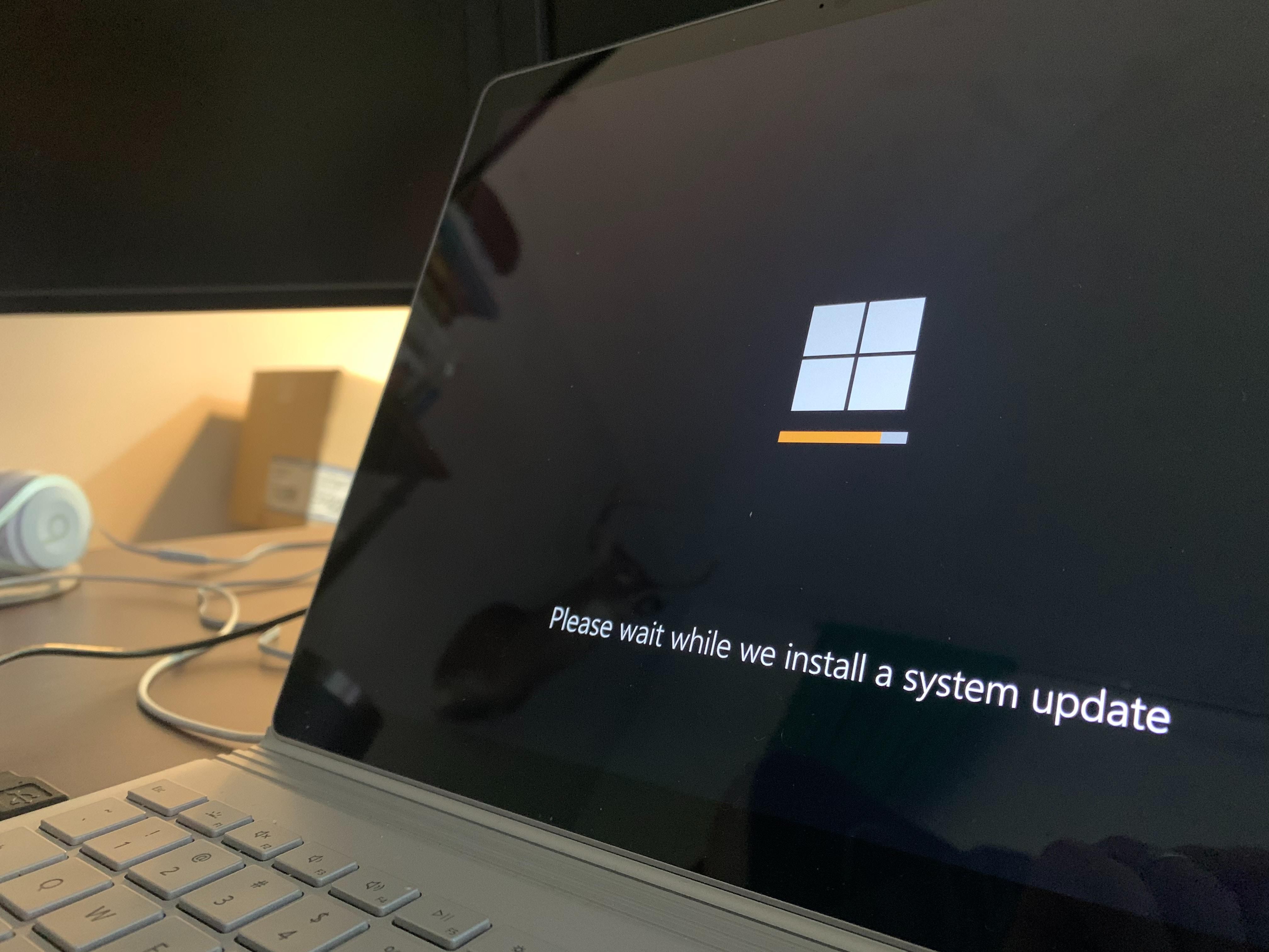 A Microsoft Windows épp frissítéseket telepít egy laptopon, ami egy asztalon van 