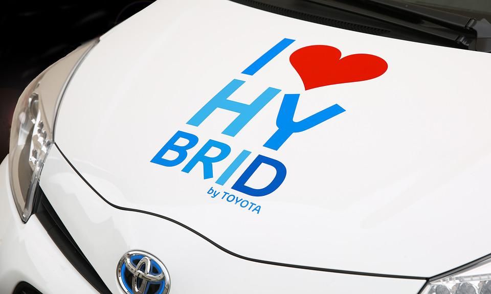Szeretem a hibridet felirat egy fehér Toyota hibrid meghajtású autó motorháztetőjén