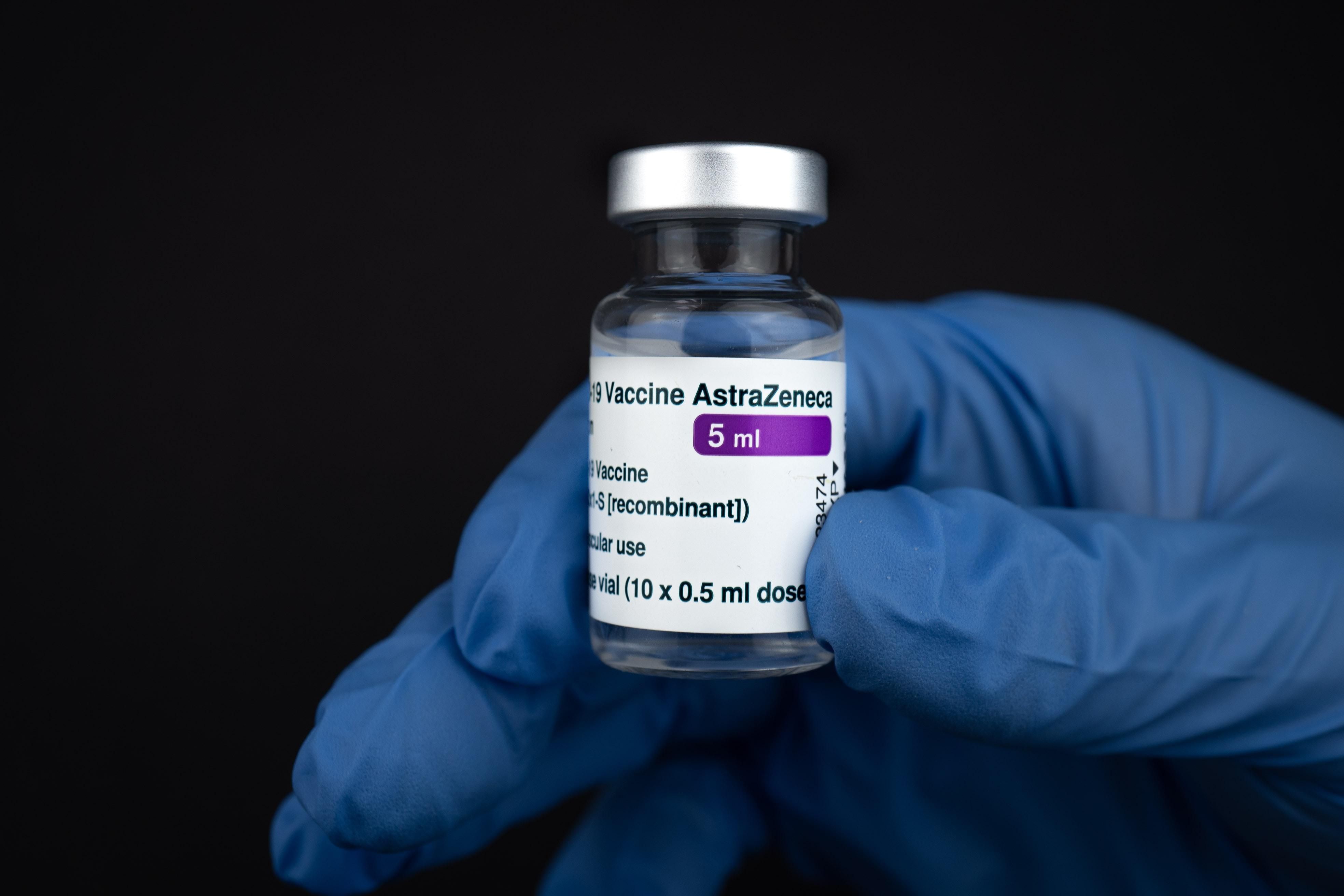 Egy orvos kesztyűben a kezében tartja az AstraZeneca koronavírus elleni oltóanyagát