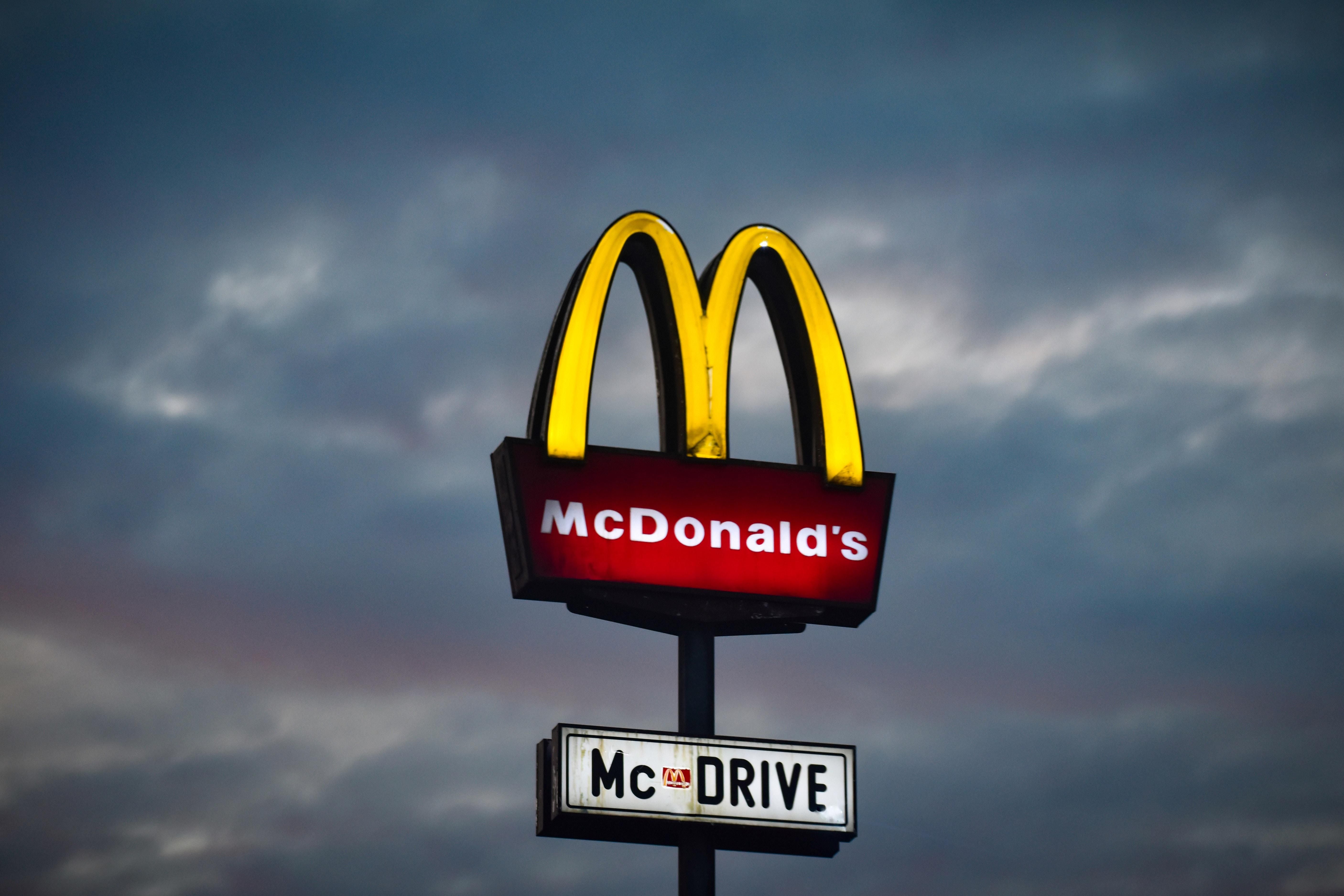 Fehéren, pirosan és sárgán világító McDonald's logó, alatta McDrive táblával