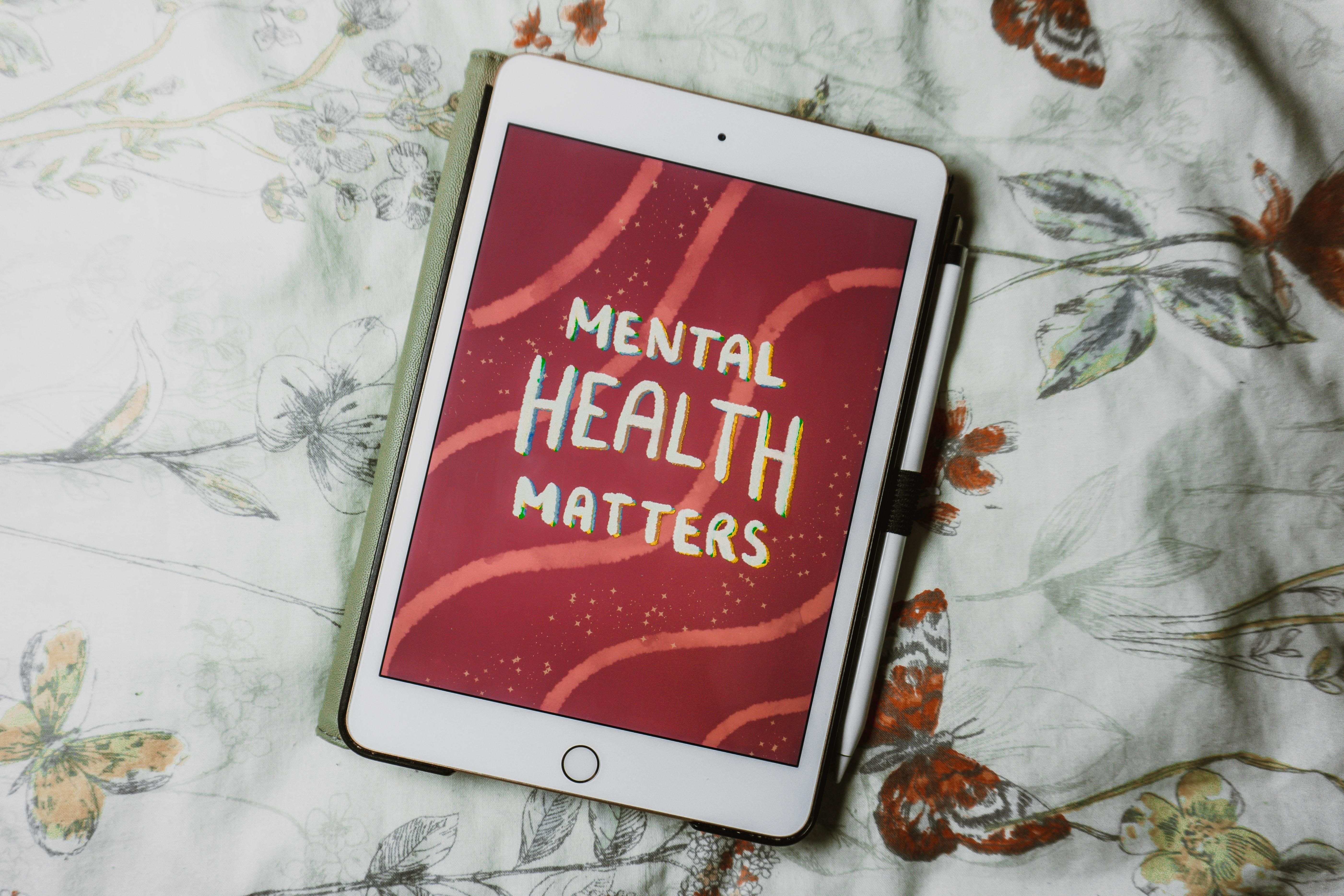Mental health matters felirat egy iPad-en piros háttérrel egy ágytakarón.