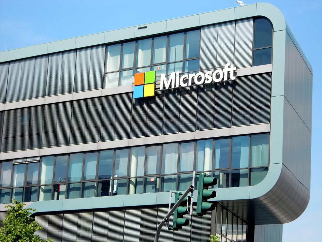 Microsoft logó egy nagy épületen közlekedési lámpákkal az előtérben