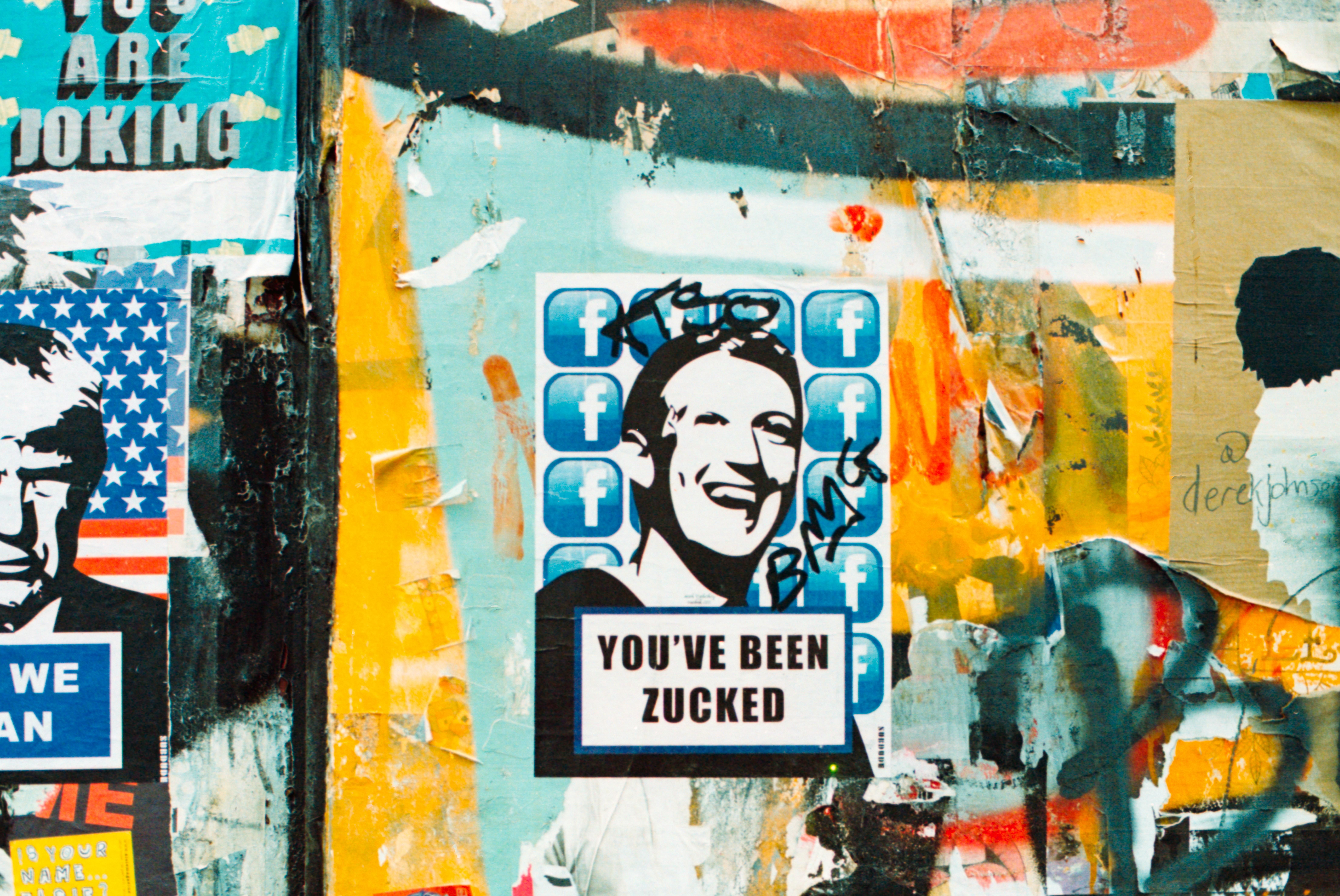 Mark Zuckerberg képe egy graffitis falon "You've been Zucked" felirattal