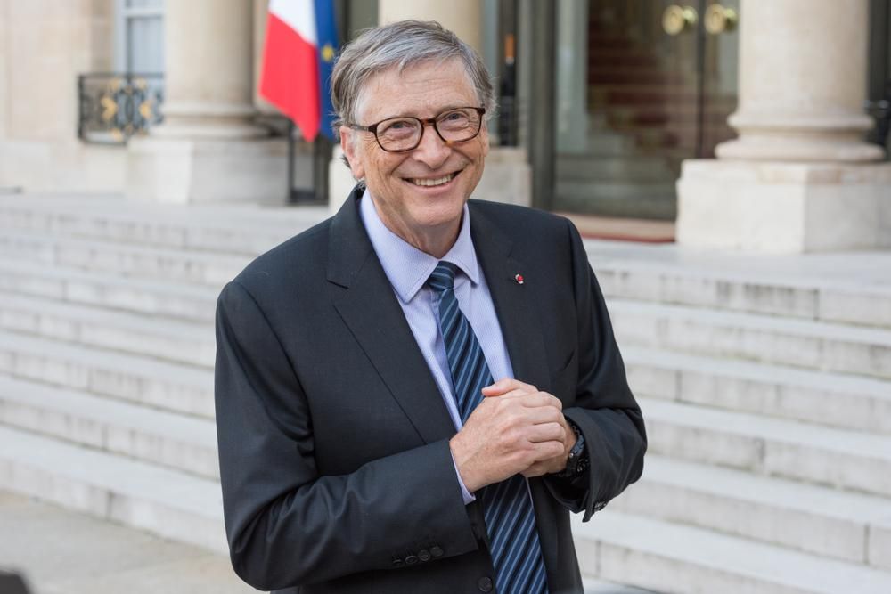 Bill Gates, az egyik leggazdagabb ember öltönyben a kezeit dörzsöli és mosolyog