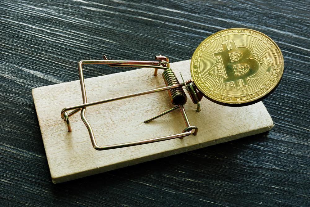Befektetési csalást sugalló kép egy egércsapdára helyezett bitcoinról