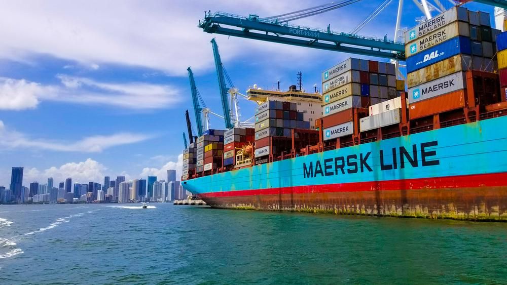 A Maersk konténerszállító hajótársaság egyik konténerhajója rakományával épp egy város kikötőjét közelíti meg