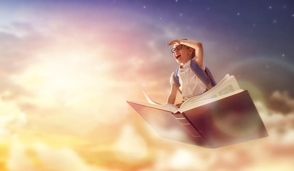 A Kami vállalat platformját használó kisgyerek élvezi a tanulást, miközben egy könyvön repül