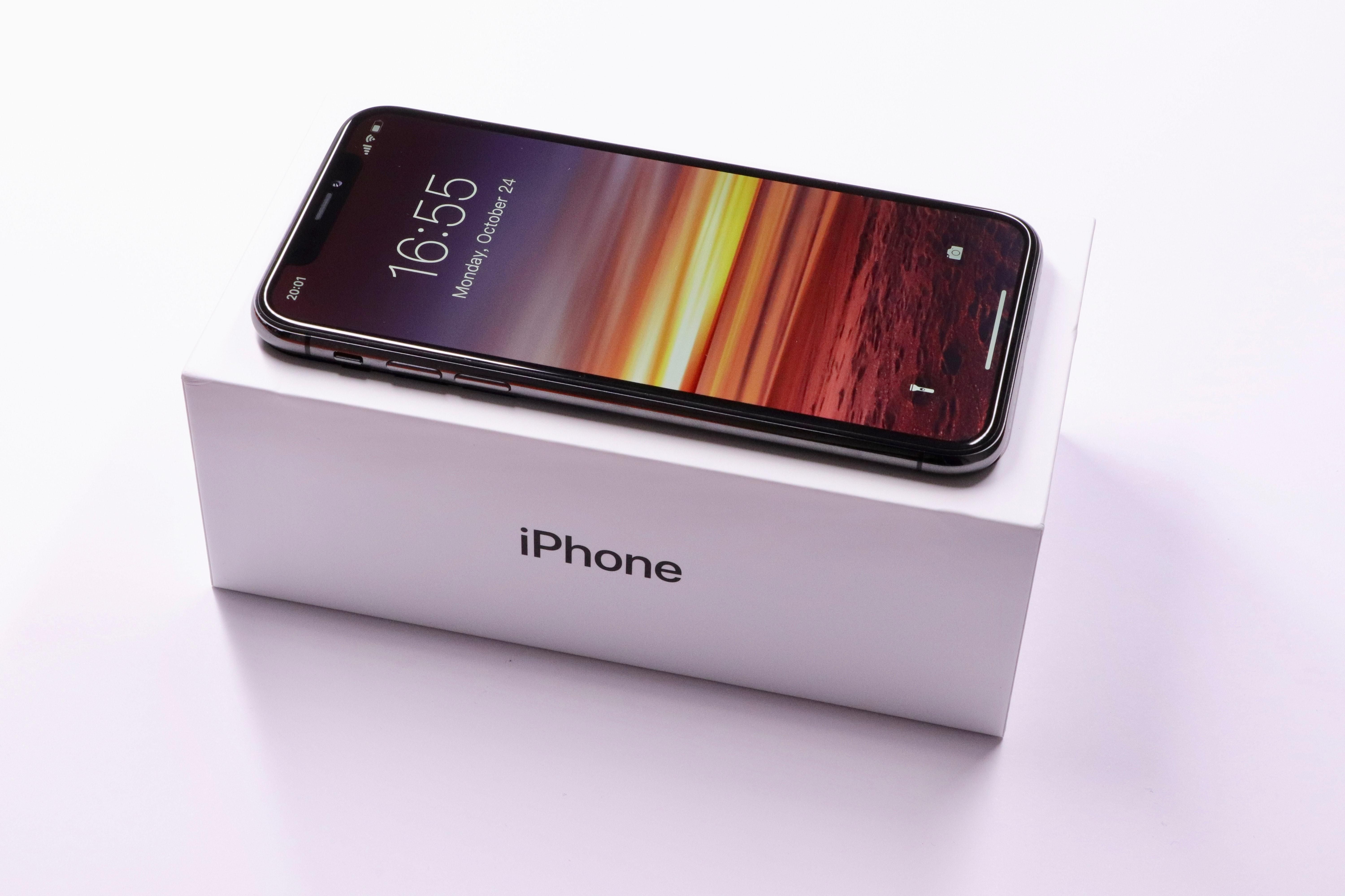 Egy iPhone X okostelefon a dobozán fehér háttérben