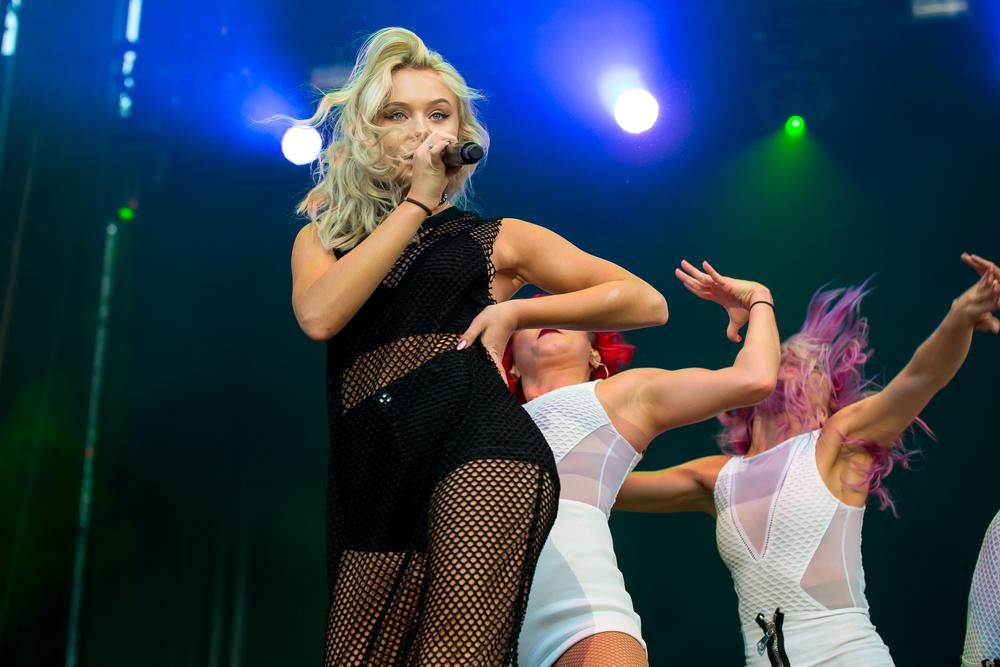 Zara Larsson popsztár a színpadon énekel táncosnőkkel a háttérben