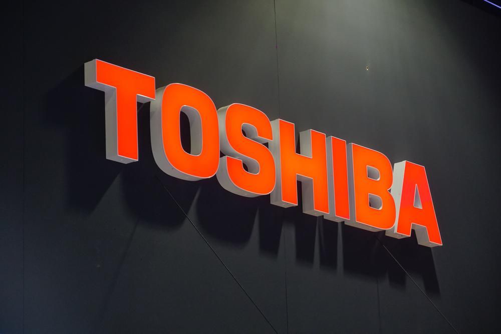 A Toshiba narancssárga logója egy sötét falon