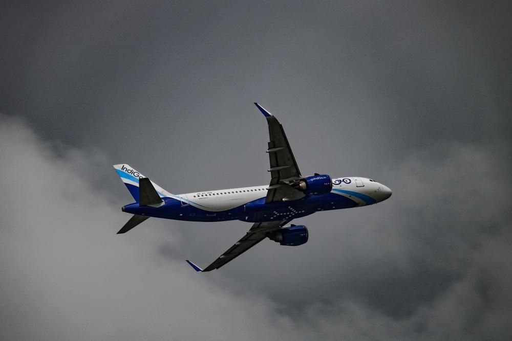 Az Indigo egyik kék-fehér repülőgépe, amit az Airbustól vásárolt, épp egy borongós, viharos napon repül a célja felé