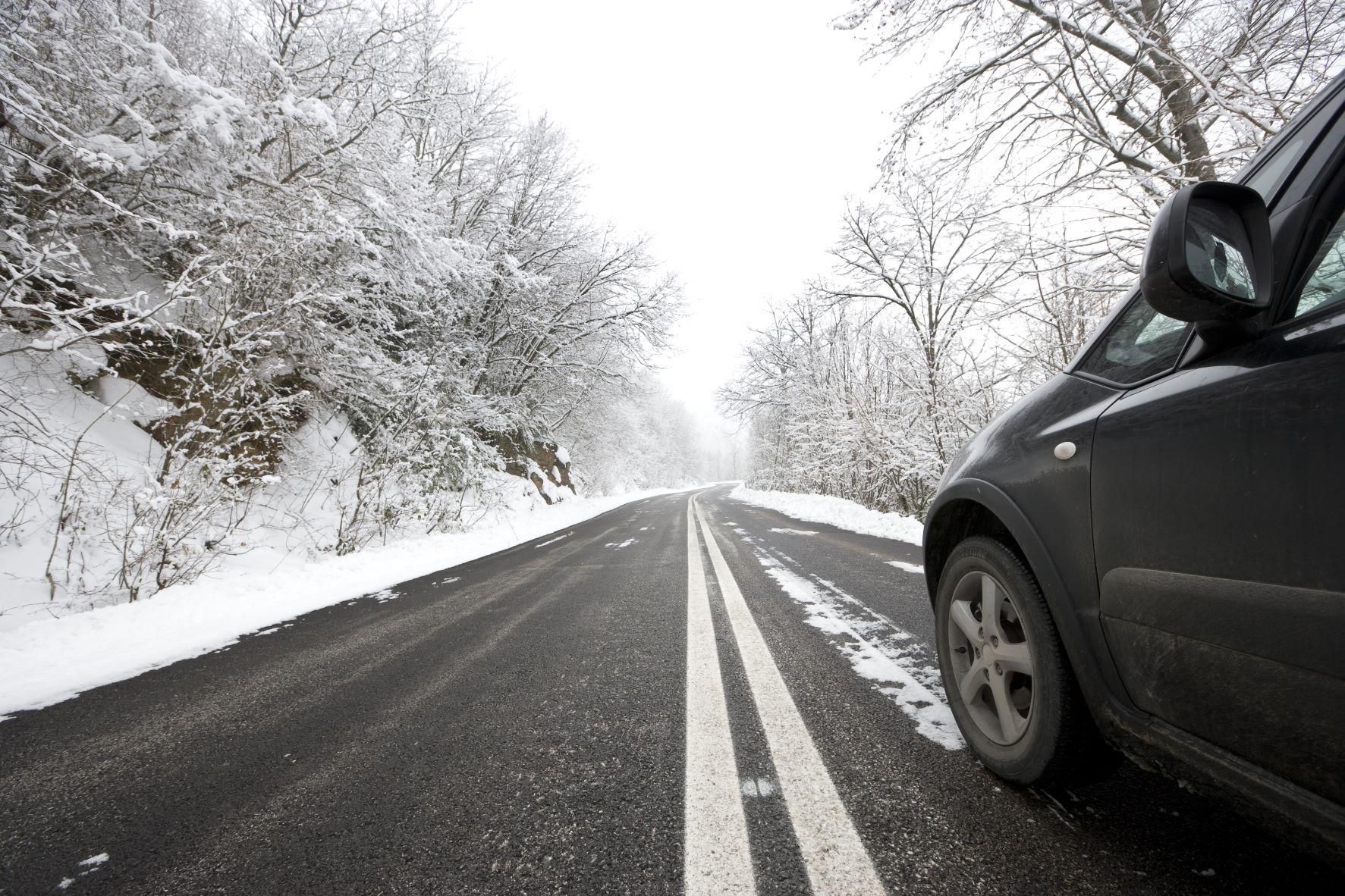 Fekete autó halad a havas úton