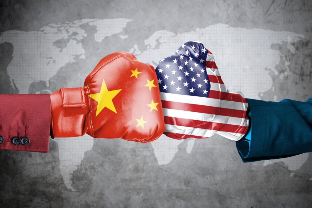 Két ember kínai és amerikai zászlókkal díszített bokszkesztyűvel összeüt a szürke világtérkép előtt