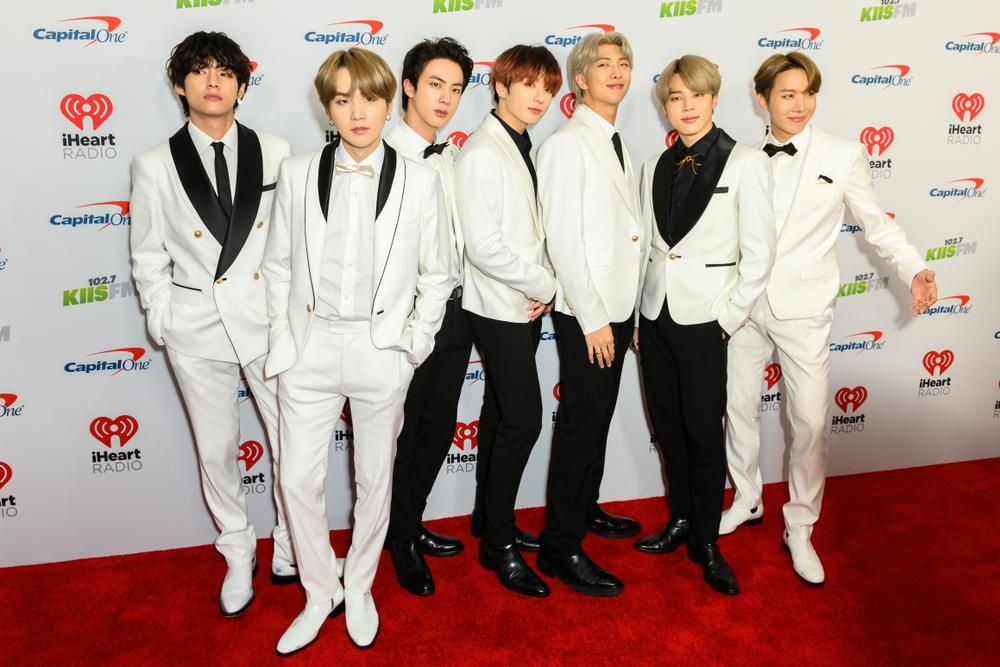 A BTS K-pop fiúbanda hét tagja a vörös szőnyegen fehér zakóban