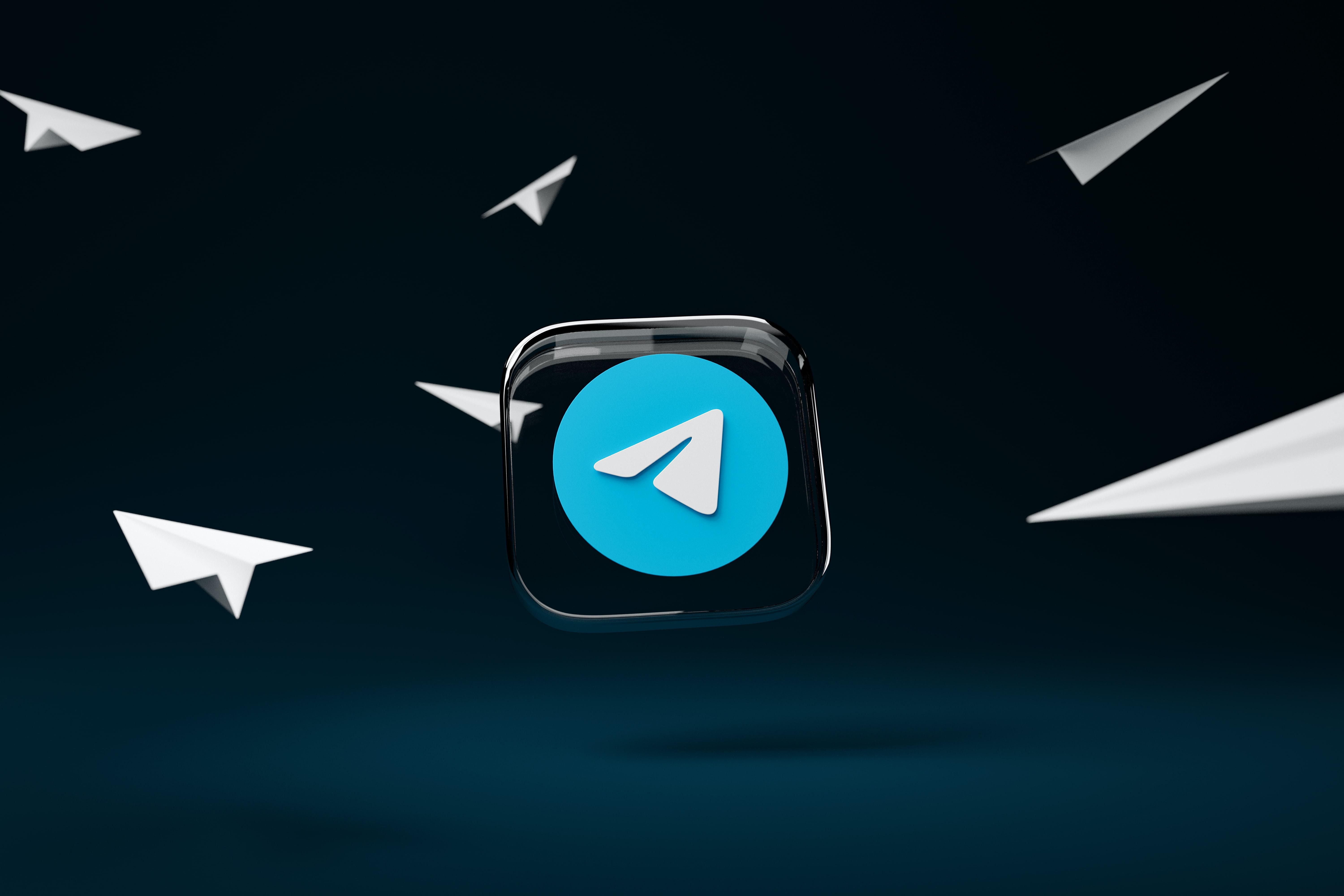 A Telegram kék-fehér logója egy üvegben, amely körül papírrepülők repkednek