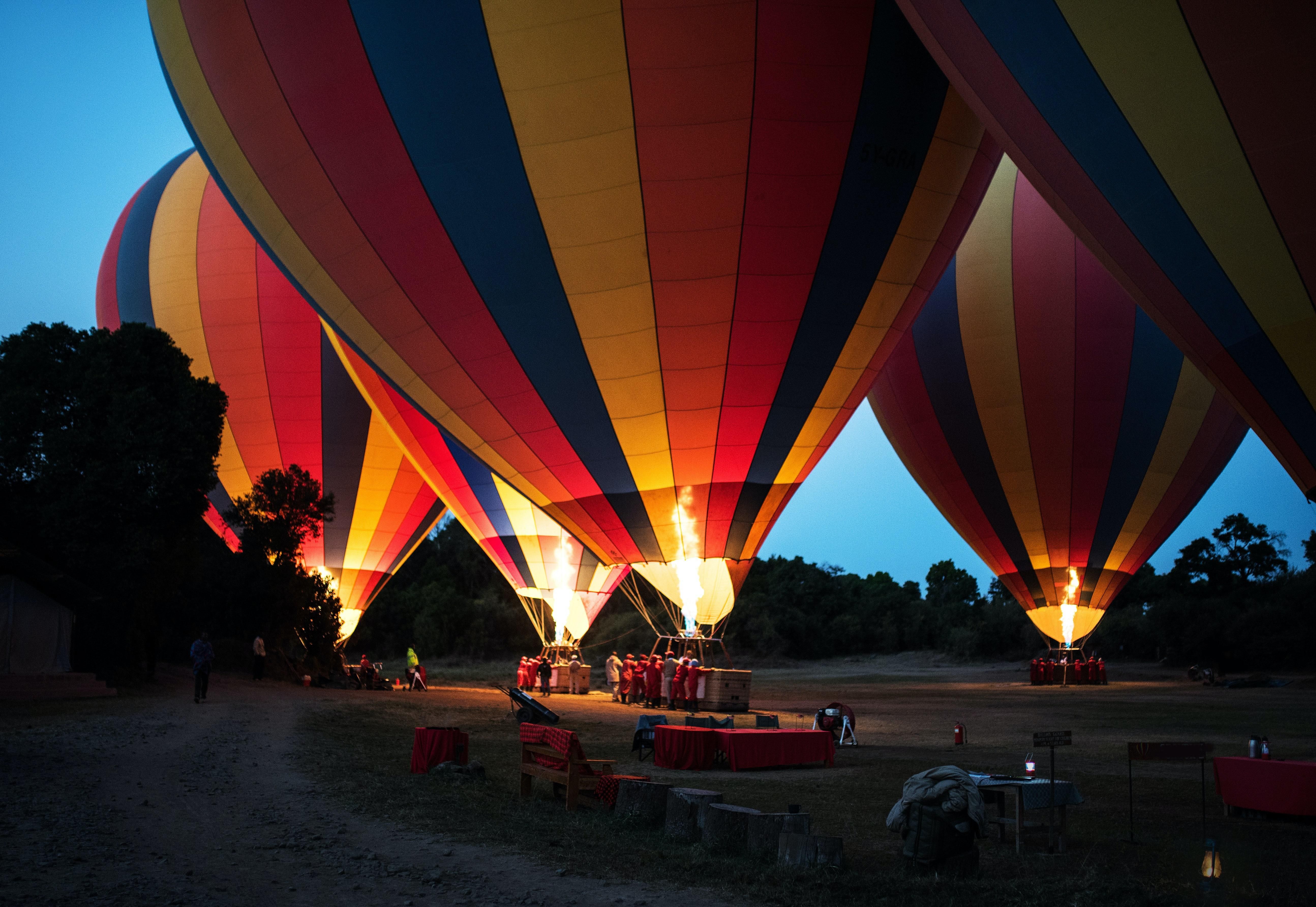 Sötétedéskor felszállásra készülő színes hőlégballonok