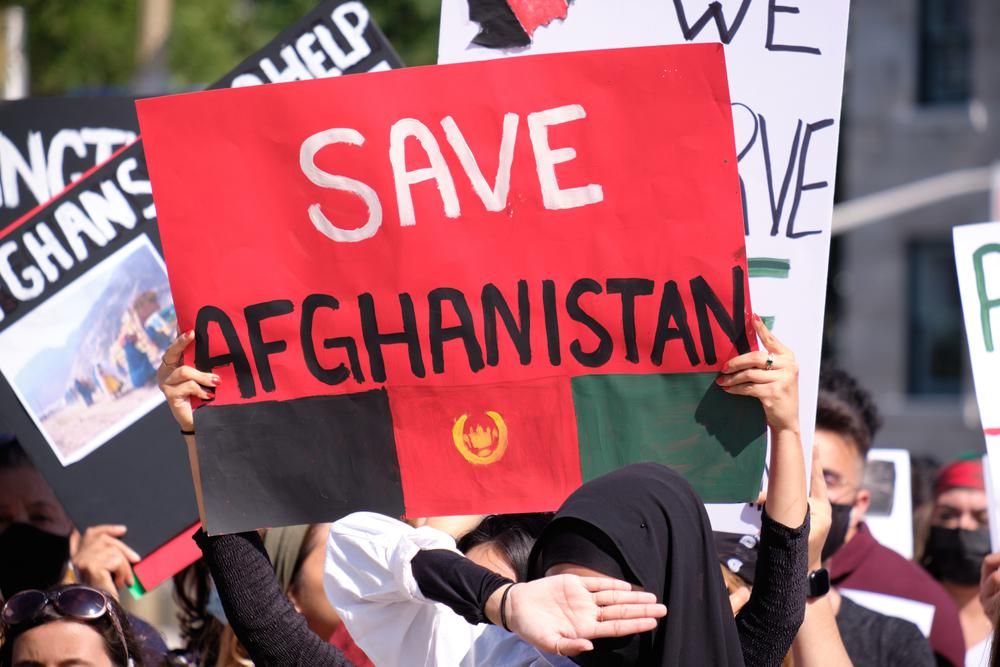 Nők tiltakoznak Afganisztánban, miután Kabult elfoglalták a tálibok, az egyik nő "Save Afghanistan" feliratú táblát tart a kezében