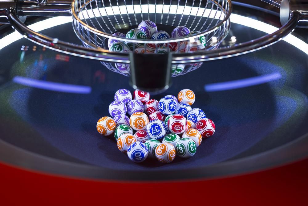 Zöld, kék, sárga, piros és lila számgolyók segítségével épp kisorsolják az aktuális lottó nyerőszámokat