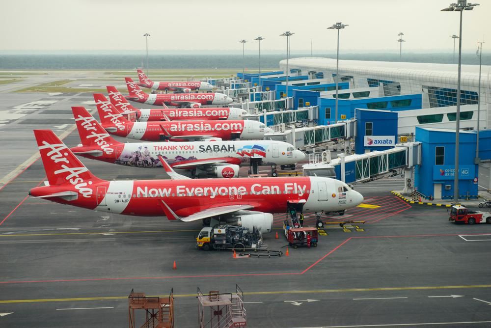 Az AirAsia piros-fehér repülőgépei sorakoznak egymás mellett a repülőtéren