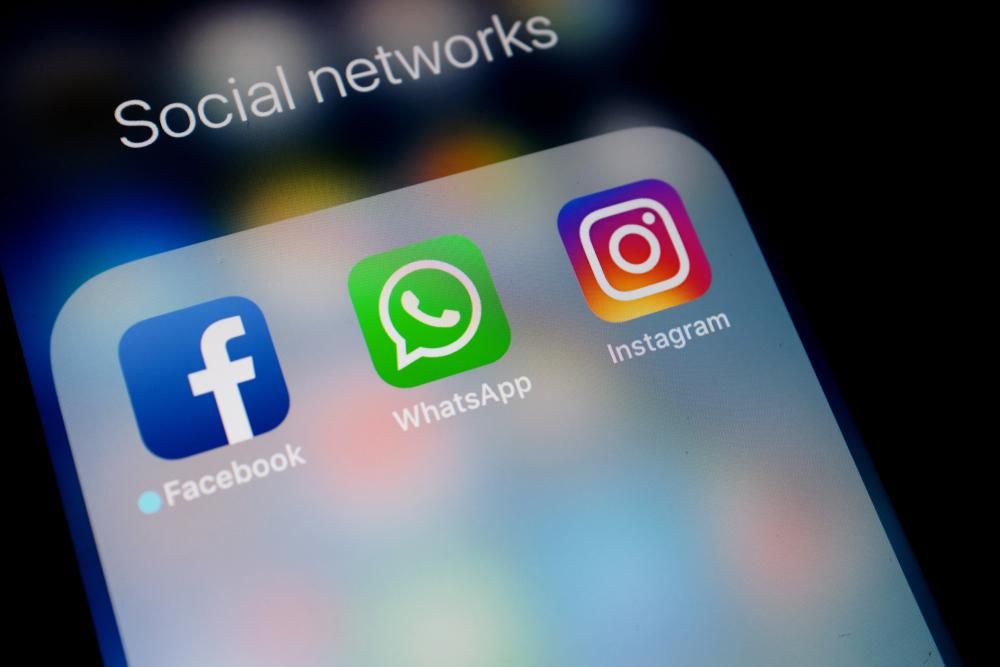 A Facebook, a WhatsApp és az Instagram alkalmazásainak logója egy telefon képernyőjén, amelyek egy social networks nevű appgyűjtőben jelennek meg