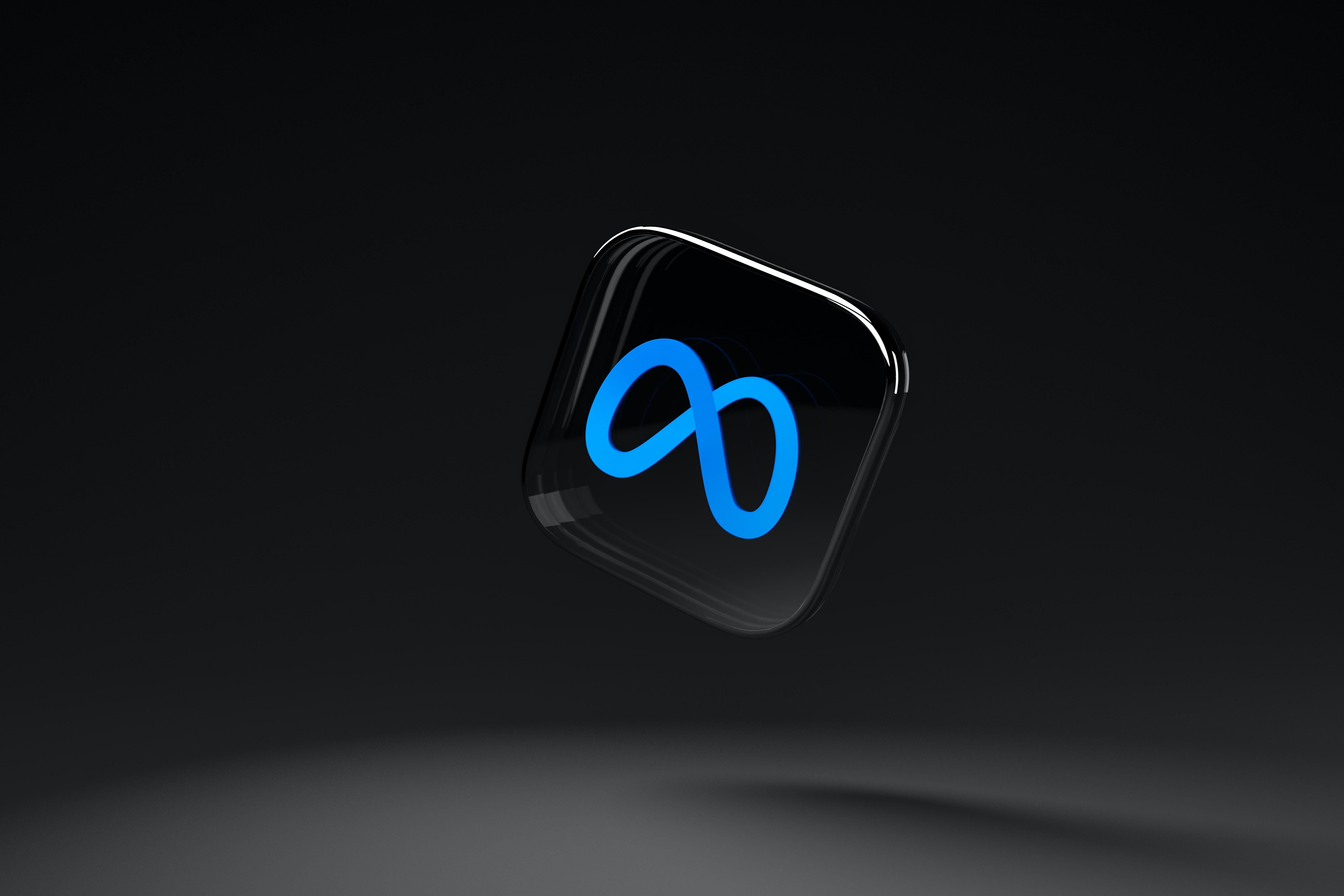 Az egybillió forintos perrel szembe néző Meta Platforms kék-fekete logója egy sötét környezetben, a Meta a Facebook anyavállalata