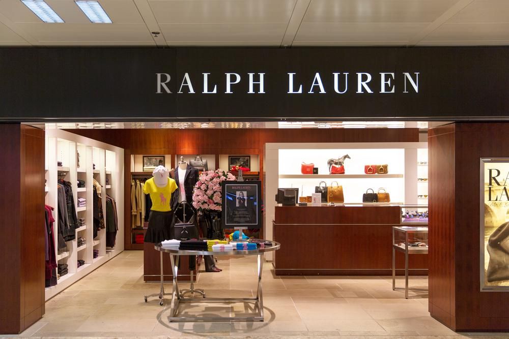 A Ralph Lauren divatcég egyik ruhaüzlete egy bevásárlóközpontban, próbababák, férfi és női ruhák, táskák, kiegészítők  láthatók a képen