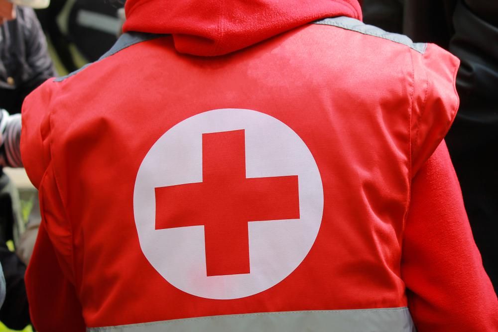 A Vöröskereszt piros-fehér logója egy segélyszervezeti tag piros mellényének hátulján