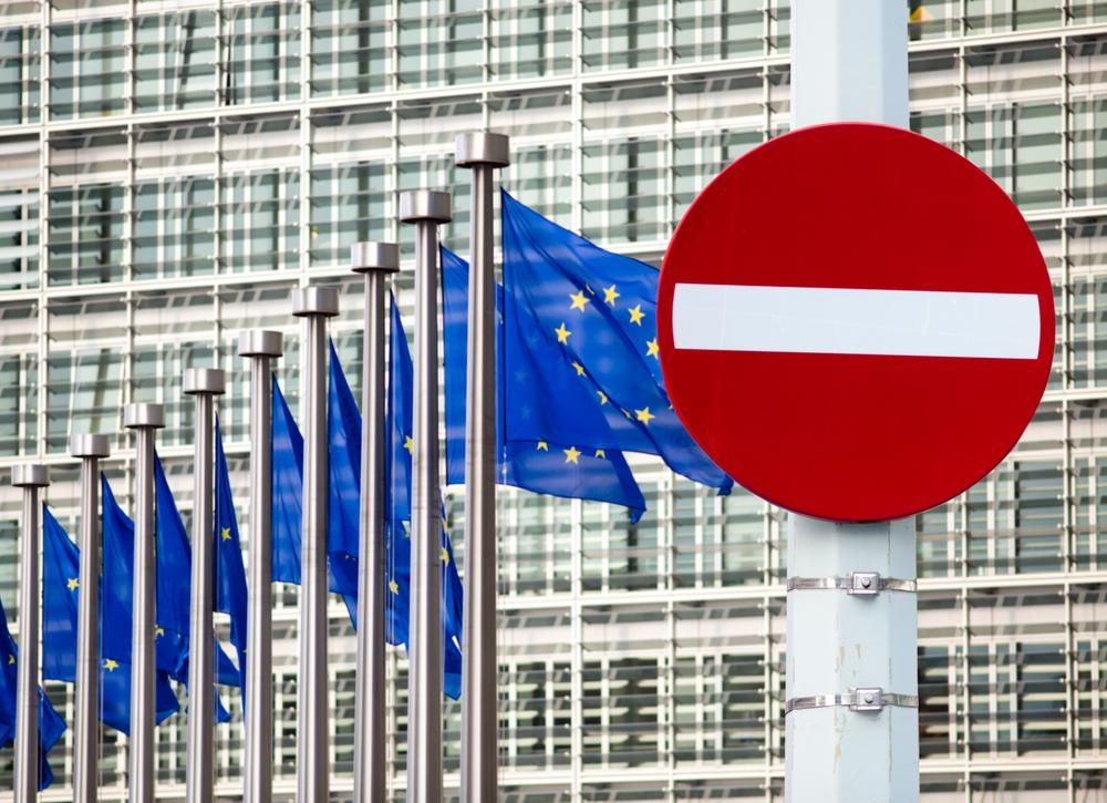 Az Európai Unió zászlói az Európai Bizottság előtt, egy behajtani tilos tábla van a zászlók mellett
