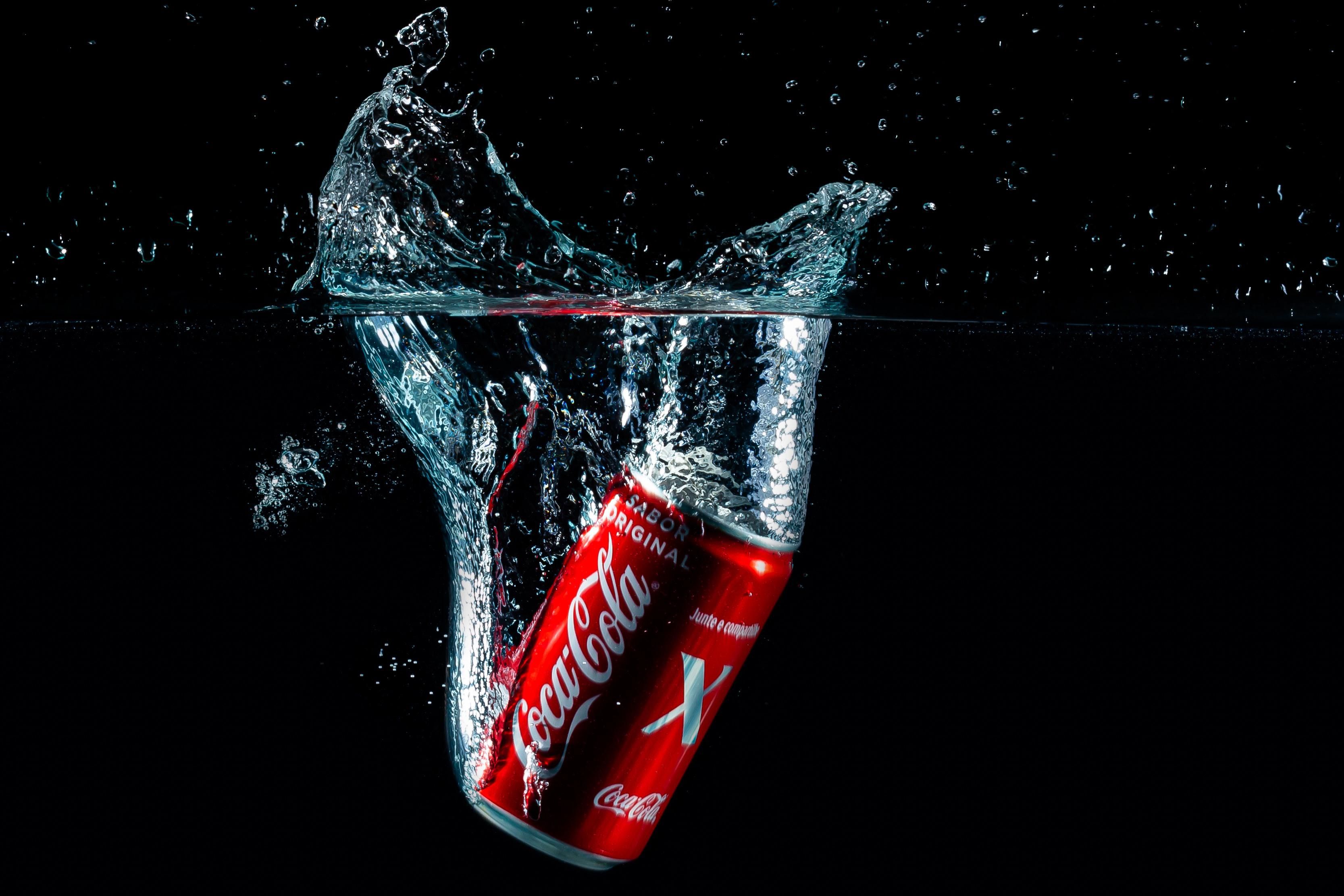 Egy dobozos Coca-Cola elmerül a vízben környezetszennyező módon