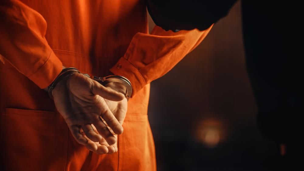 Narancssárga rab ruhában, bilincsben kíséri a börtönőr a cellájába az informatikust, aki meghackelte munkaadói rendszereit
