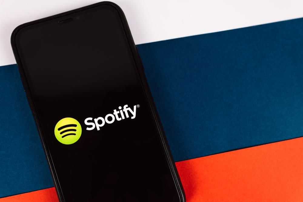 A Spotify logója egy okostelefon képernyőjén, amely az orosz zászlón van