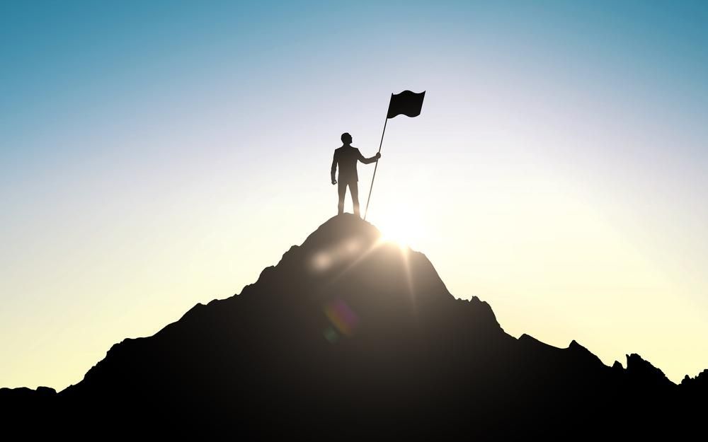 Egy ember , aki 30 felett lett sikeres, kitűzte zászlóját egy hegy tetejére