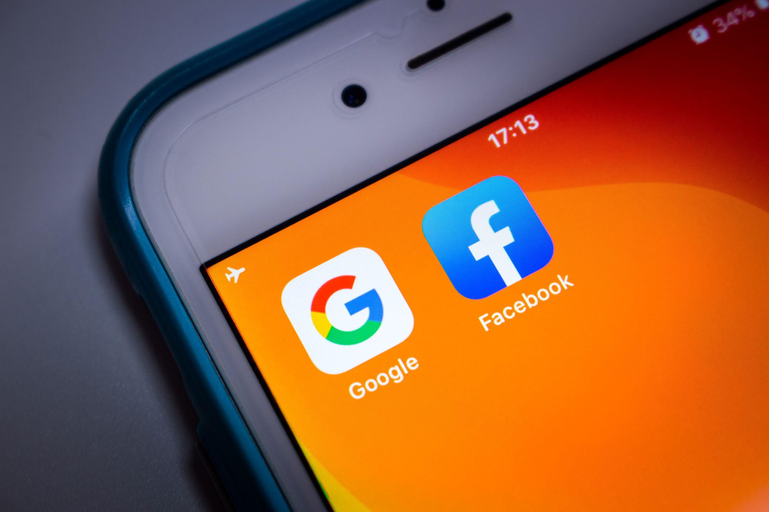 A Google és a Facebook ikonja egy okostelefonon, vizsgálja Brüsszel a két óriás egyezségét