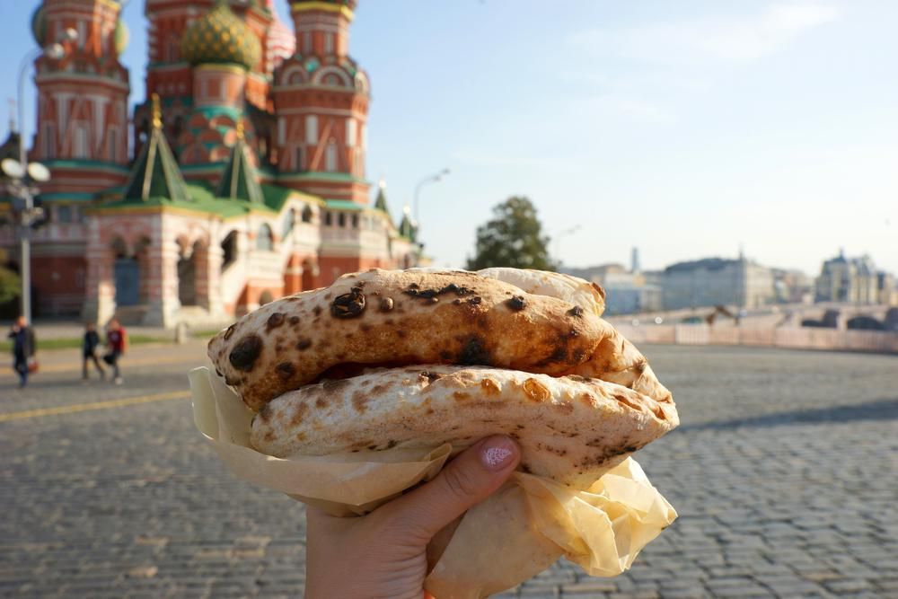 A Vörös téren egy nő street foodot tart a magasba