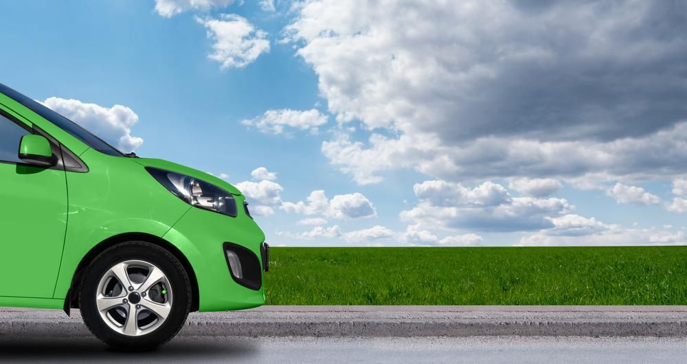 Zöld színű elektromos autó a természetben