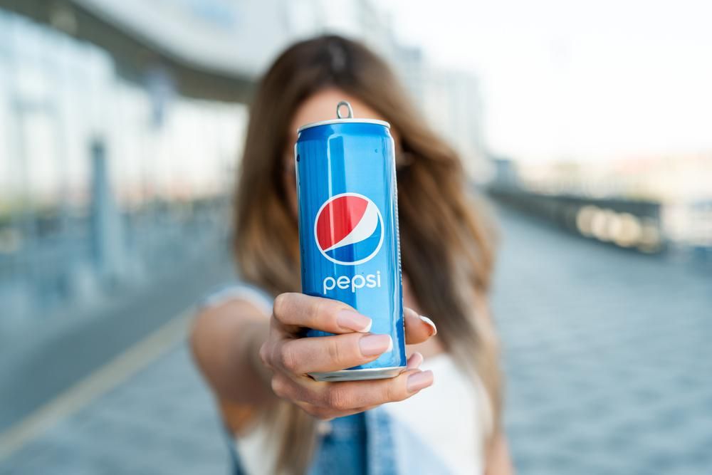 Fiatal lány tart a kezében egy dobozos Pepsit