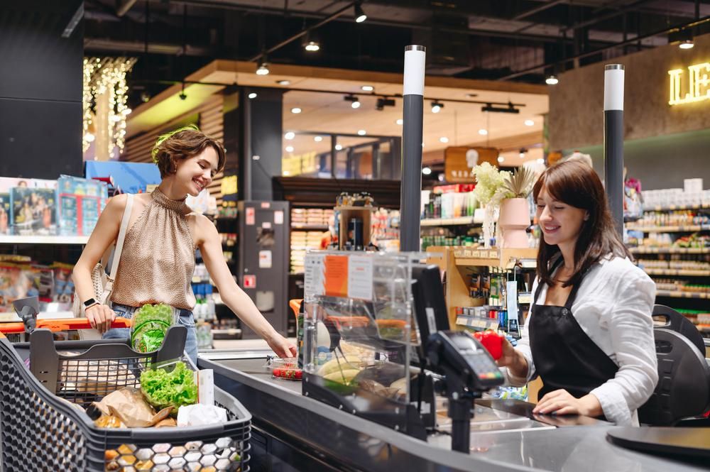 Fiatal nő kaját vesz a szupermarketben a pénztárnál