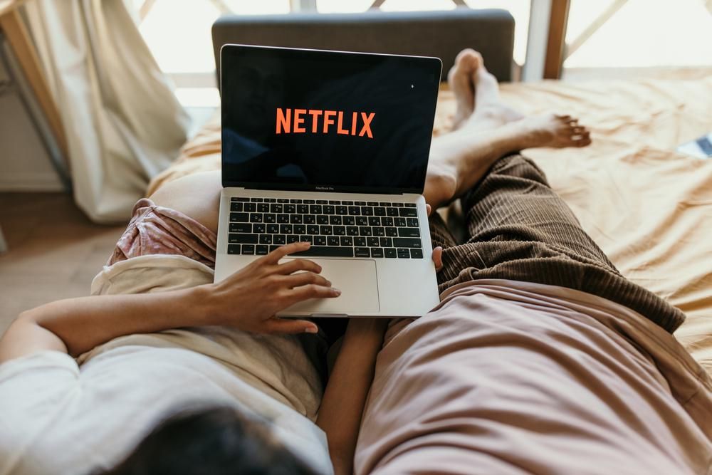Ágyban néznek Netflixet laptopon