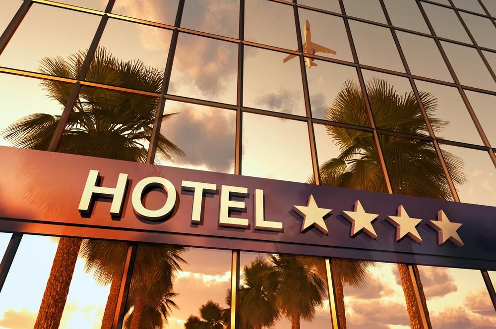 Négycsillagos hotel üvegablakán pálmafák tükröződnek
