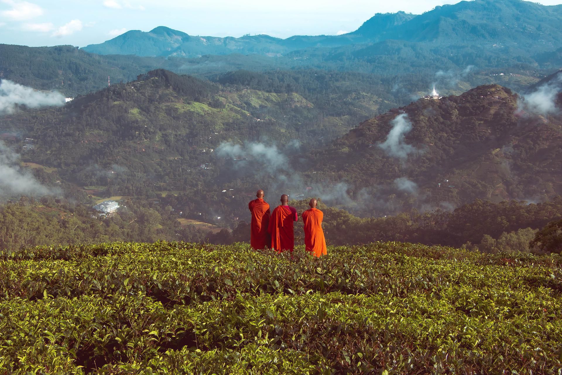 Sárga ruhába öltözött három szerzetes a hegy előtt