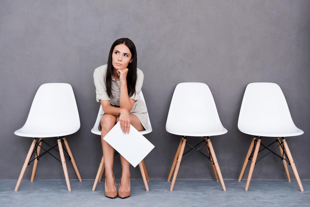 Fiatal nő ül egy széken állásinterjúra várva