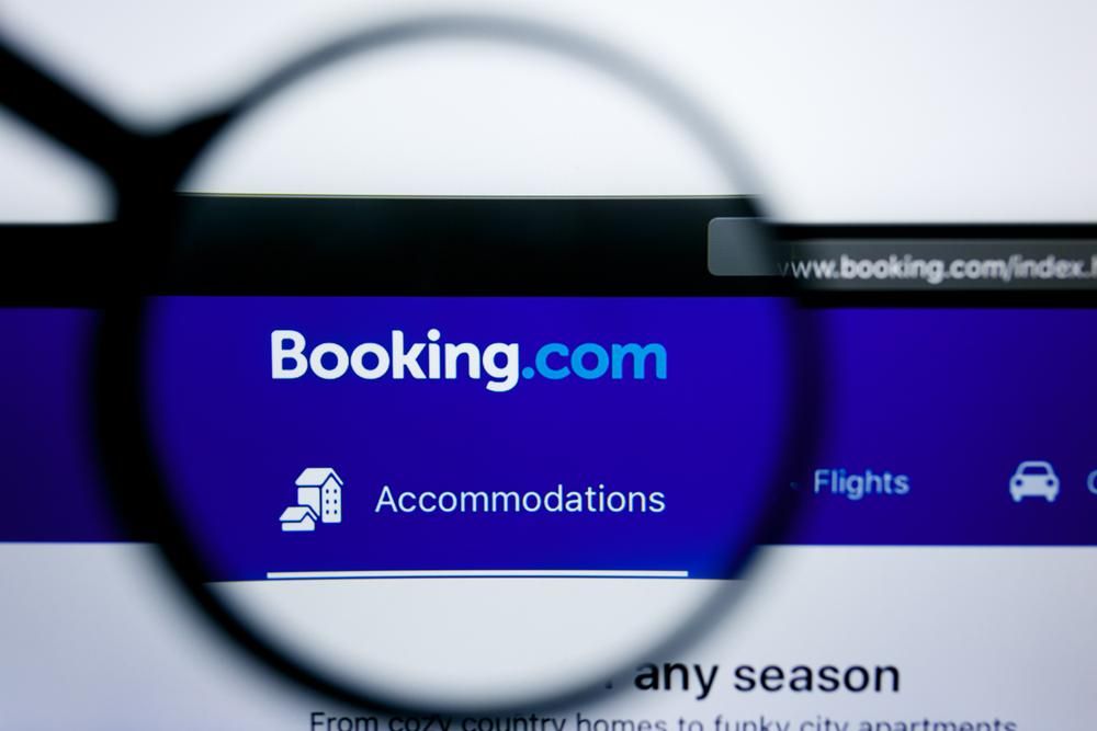 Booking.com szálláskiadó kék logója nagyítóval