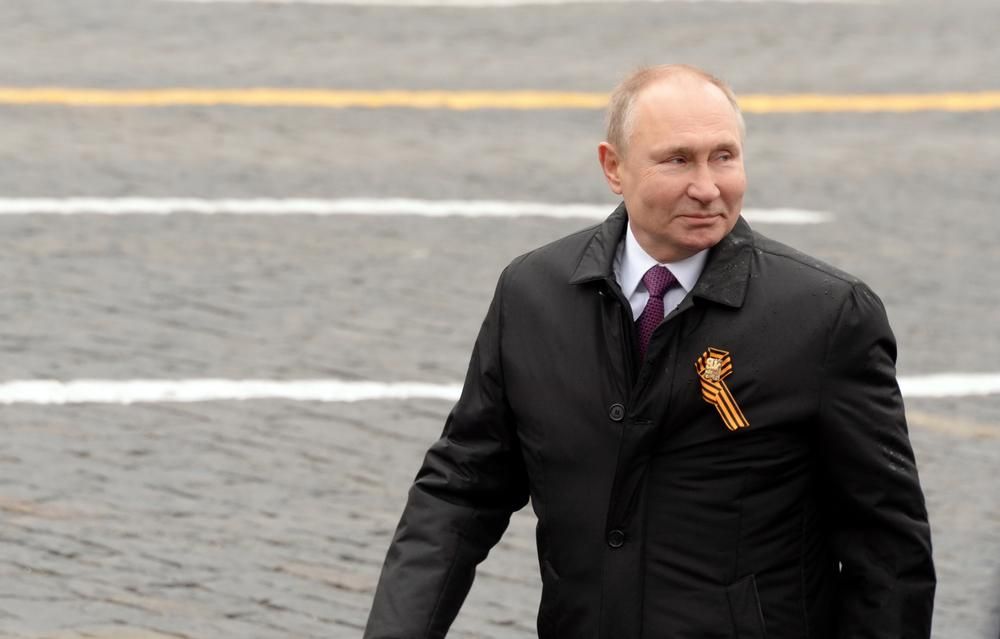 Putyin orosz elnök fekete kabátban mosolyog