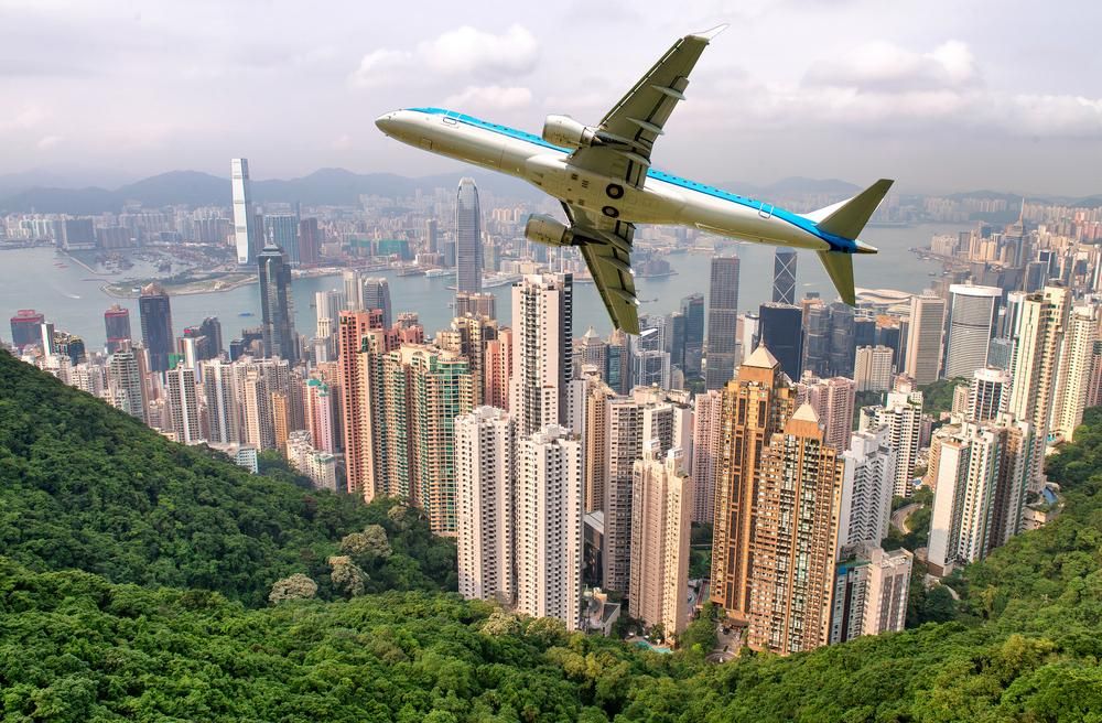 Repülőgép húz el Hongkong felett