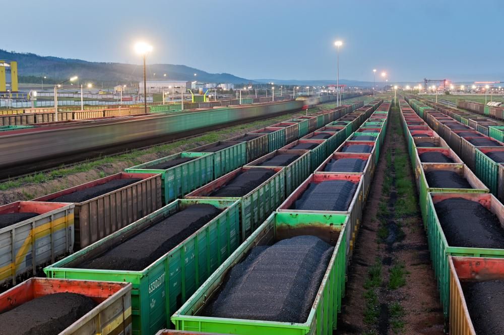 Fekete szén zöld szállítóvagonokban vasúton