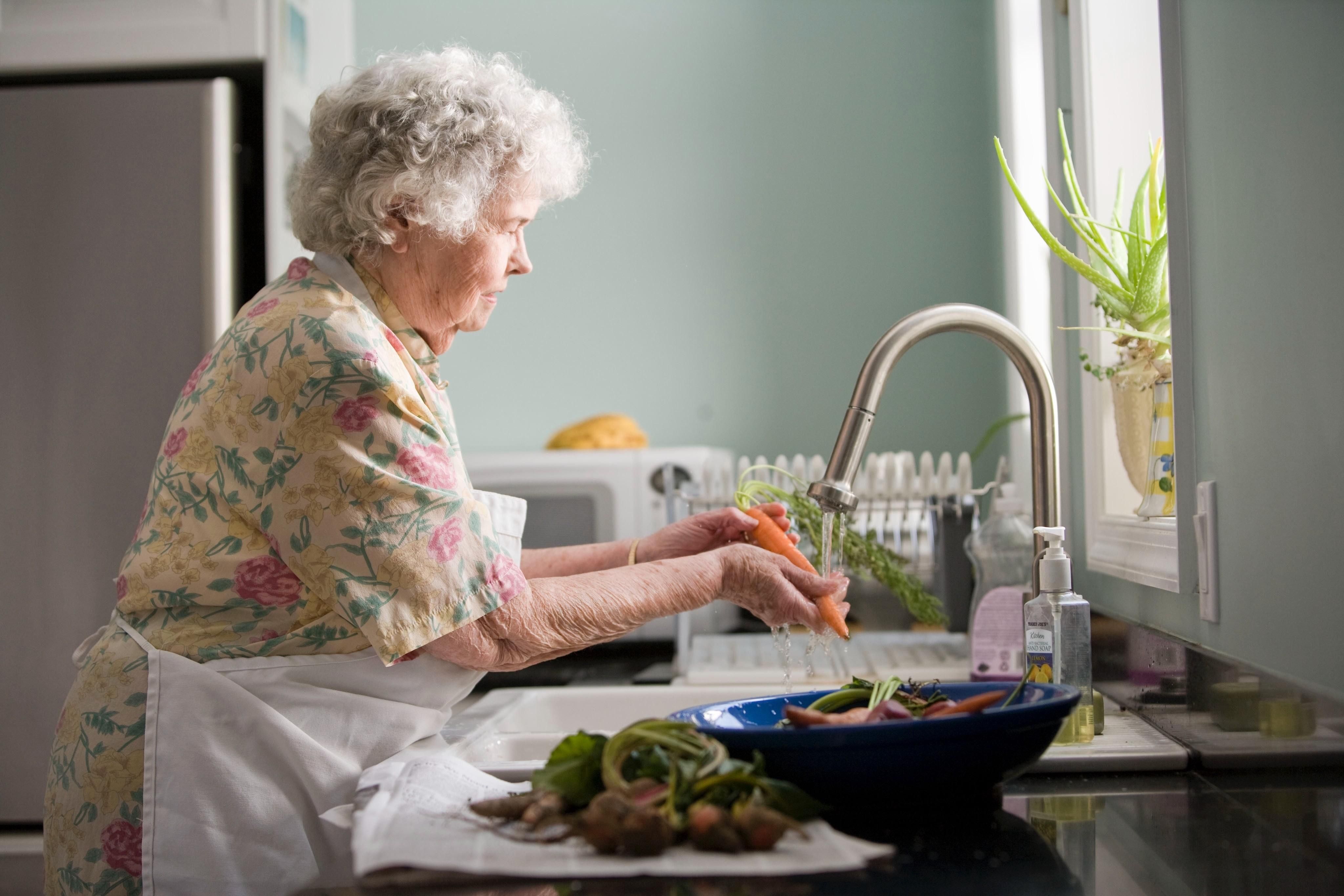 Zöldséget mosó nyugdíjas néni