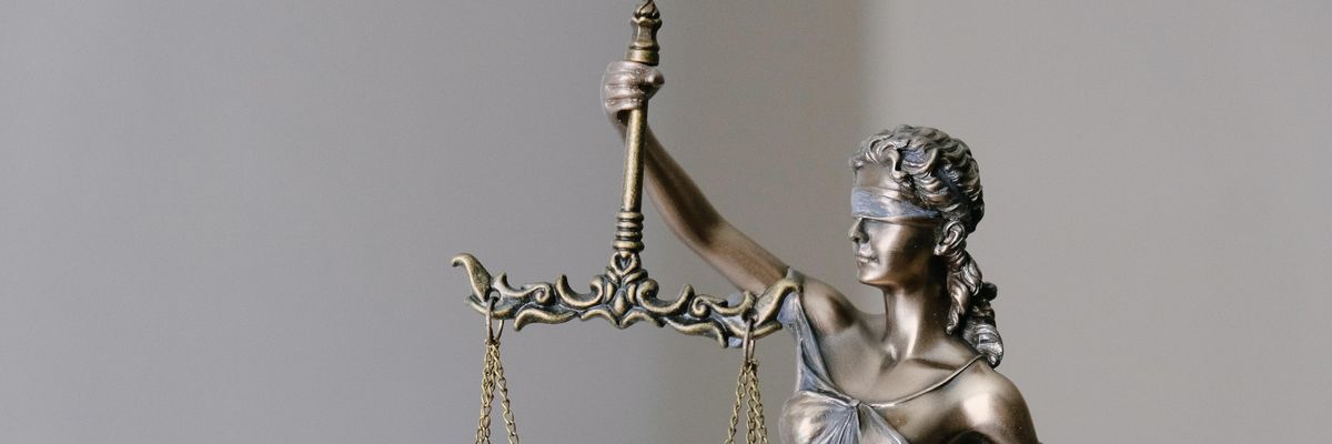 Iustitia, az igazság, az igazságszolgáltatás és az erkölcsi erő istennőjének szobra egy bíróságon, egy mérleget tart a kezében és be van kötve a szeme
