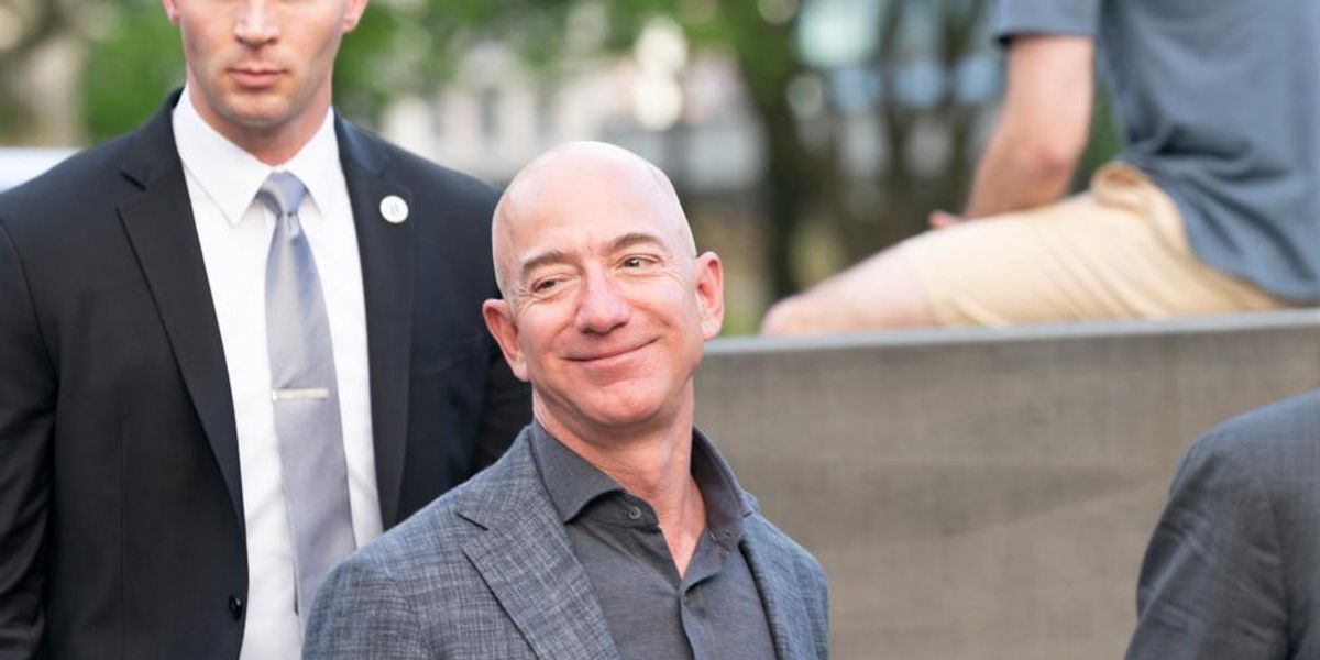 Jeff Bezos öltönyben mosolyog, miután bejelentette, irdatlan összeget szentel a klímavédelemre