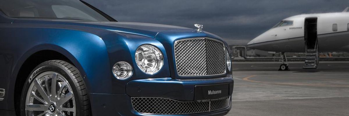 Kék színű Bentley luxusautó egy reptéren, a háttérben egy magánrepülő látható