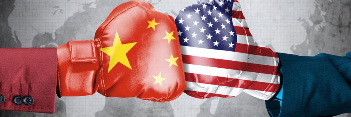 Két ember kínai és amerikai zászlókkal díszített bokszkesztyűvel összeüt a szürke világtérkép előtt